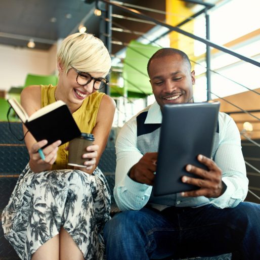 Team of young casual business people collaborating on an online project using a digital touchpad tablet computer in a bright modern office space. Serie with light flares